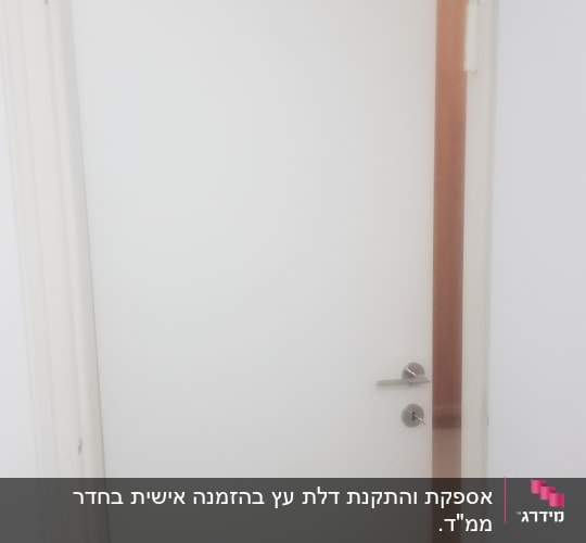 דלת לבנה עם ידית מתכת כסופה פתוחה מעט